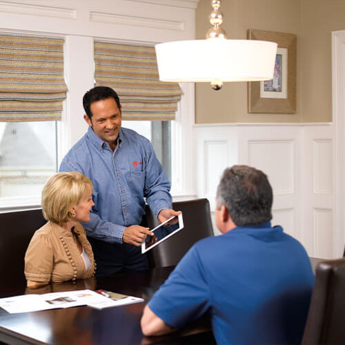 Service technician explaining savings agreements to homeowners