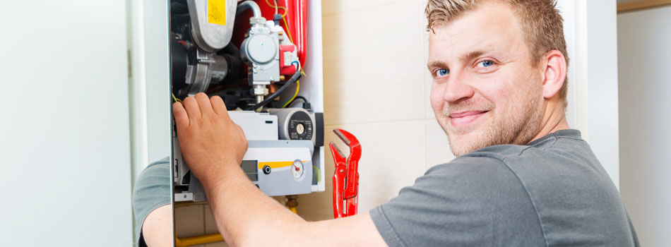 Tech using wrench to repair heater.