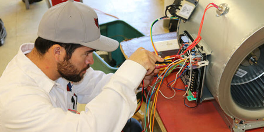 Service technician working on repairing wires in air conditioner